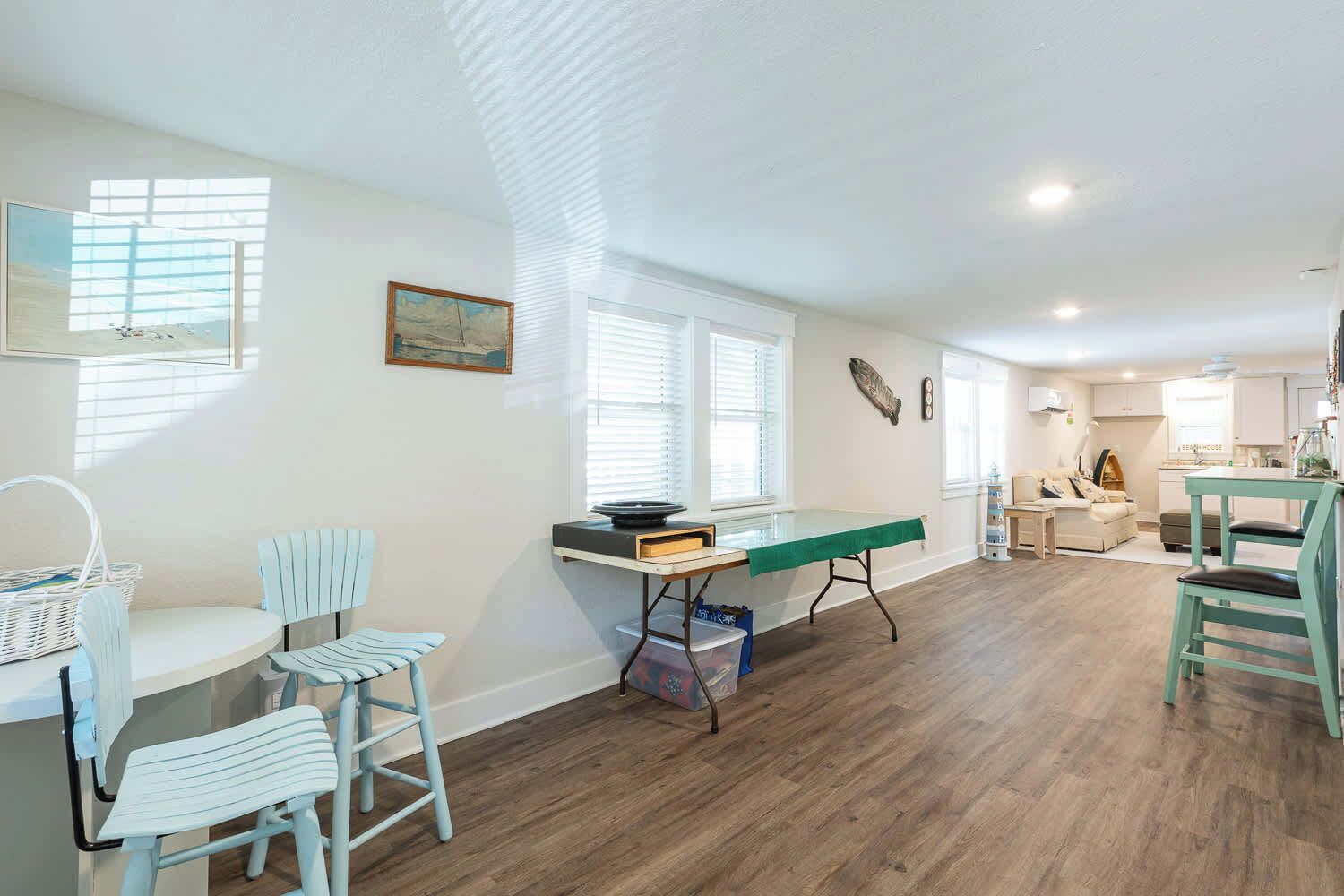 A spacious living area with a dining table, chairs, and a kitchen in the background.