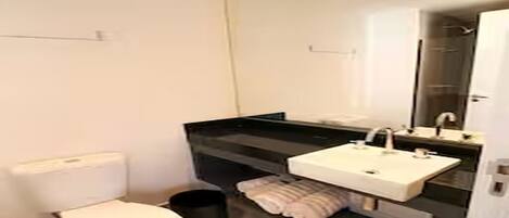 Een haardroger, handdoeken, zeep, toiletpapier