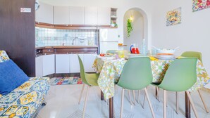 A compact living space with a dining area, kitchen, and a sofa.