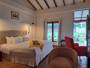 Deluxe dubbelrum - 1 queensize-säng - utsikt mot trädgården | Värdeförvaringsskåp på rummet och mörkläggningsgardiner