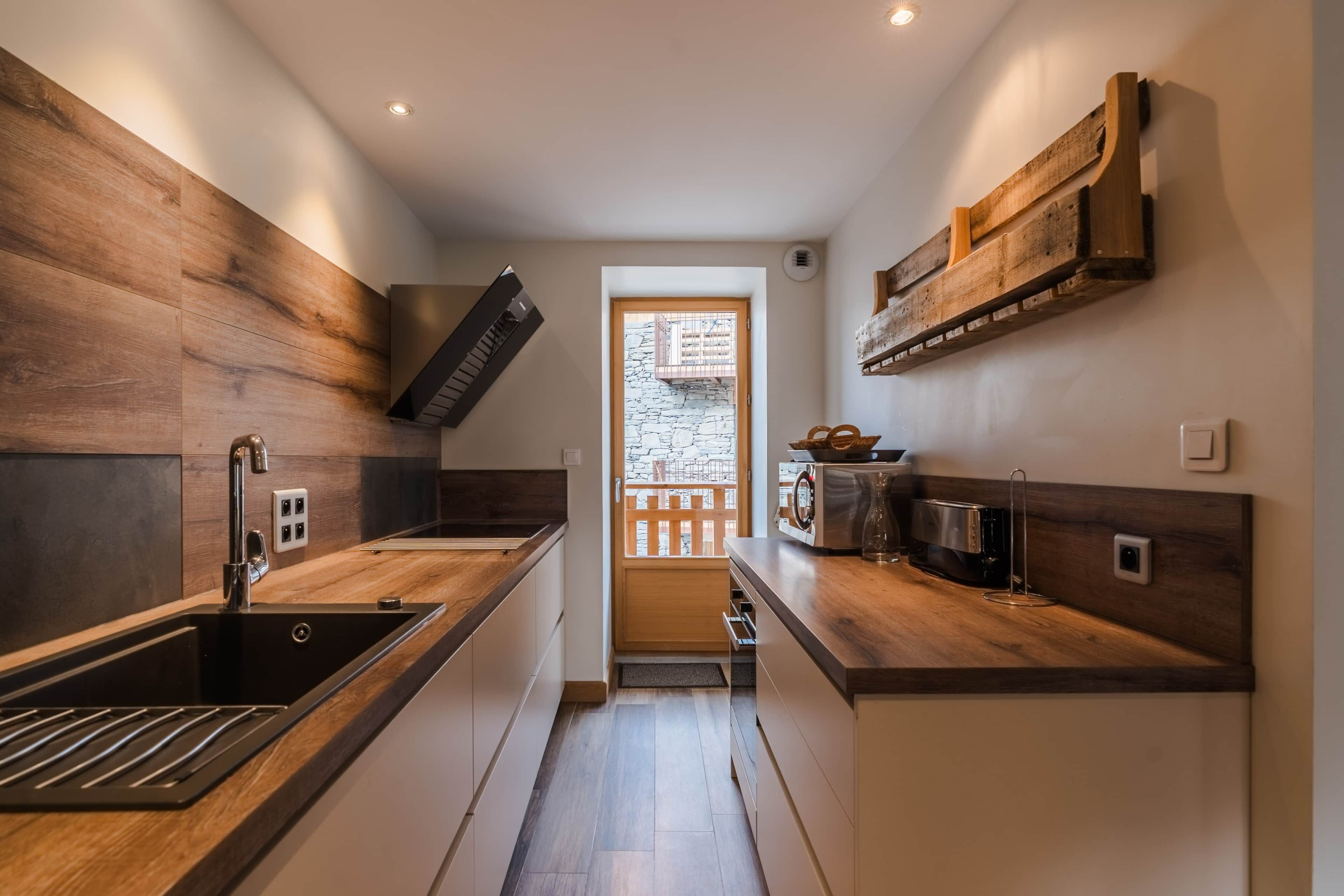 A modern kitchen with wooden cabinetry, a stainless steel sink, and a built-in oven.