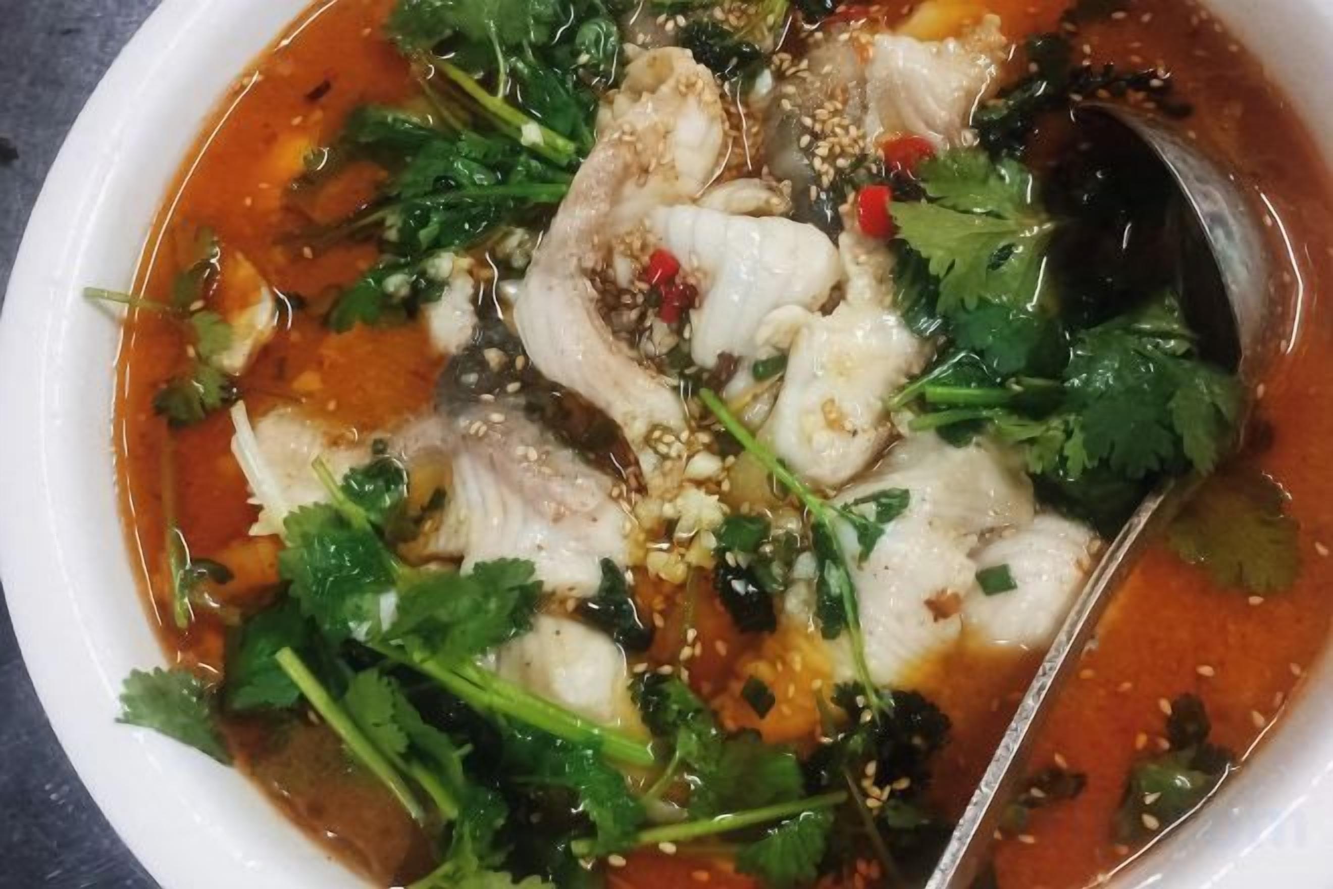 Un tazón de sopa con diversos ingredientes y una cuchara.