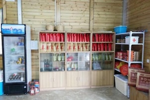 Un depósito con estantes llenos de diversos alimentos y un refrigerador para bebidas.