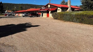 A building with a red roof, a stone chimney, and a gravel driveway. - Historic Mora Inn and RV Park (Cleveland)