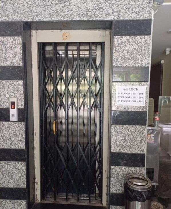 A metal gate with a sign indicating A-Block and floor numbers. - HOTEL SUN LIGHT (Vijayawada)