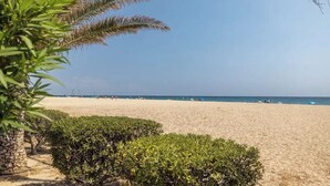 A beach with clear skies, a sandy shore, and some greenery in the foreground. - ☀️ Your Mediterranean getaway in Argelès-sur-Mer ☀️ (Unknown)