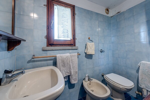 Un baño con bañera, bidé e inodoro.