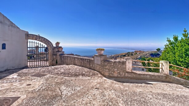 A stone pathway leading to a gate with a view of the sea. - Studio 'Al Torrione 1' with Sea View and Air Conditioning (Monte Sant'Angelo)