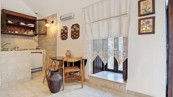 Een koelkast, een kookplaat, kookgerei, borden en bestek