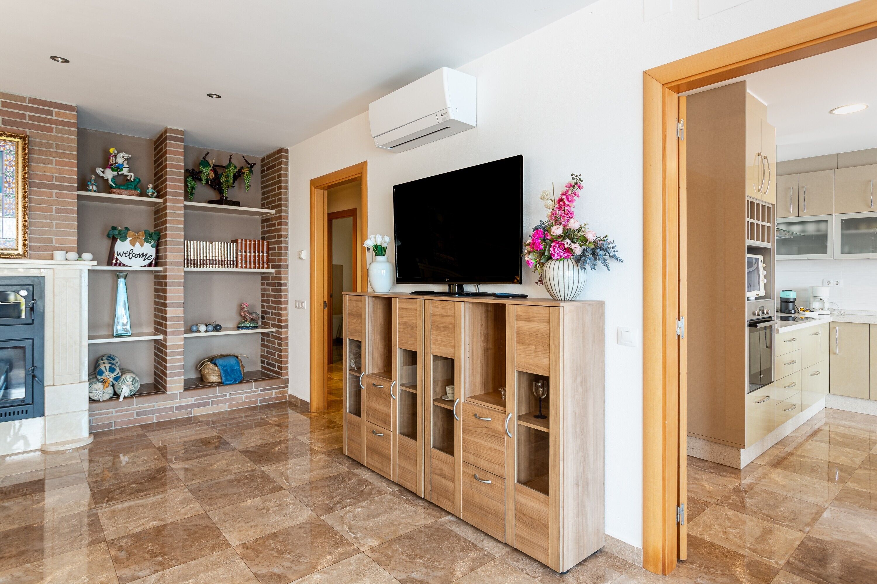 Un salon moderne doté d’un téléviseur à écran plat, de meubles en bois et d’une cheminée.