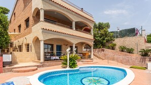 Un bâtiment à deux étages doté d’une piscine, d’un espace extérieur aménagé et d’un escalier menant à l’étage supérieur.