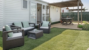 A patio area with outdoor furniture, a wooden deck, and a covered seating area.