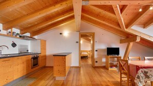 Une pièce de style loft comprenant une cuisine, un coin repas et un lit.