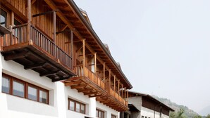 Un immeuble à plusieurs étages doté de balcons en bois et de grandes fenêtres.