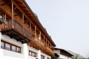 Un edificio de varios pisos con balcones de madera y ventanas amplias.