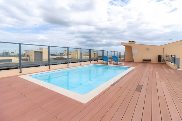 A rooftop pool with a clear view of the cityscape. - Apartment 'Marina Formosa' with Shared Pool, Wi-Fi and Air Conditioning (Olhão)