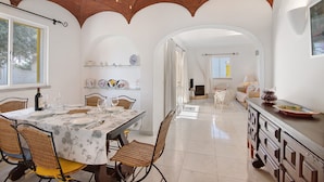 A dining area with a table set for four, a ceiling fan, and a view into the living room. - Apartment 'Sail Golf Vilamoura' with Shared Pool, Wi-Fi and Air Conditioning (Quarteira)
