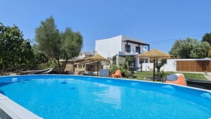 Una piscina con borde blanco y una casa moderna al fondo.