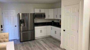 A kitchen with white cabinets, a stainless steel refrigerator, and a microwave. - GORGEOUS Studio Guest House: Q Bed, Full SZ Fridge & Full SZ Washer & Dryer, BBQ (Phoenix)