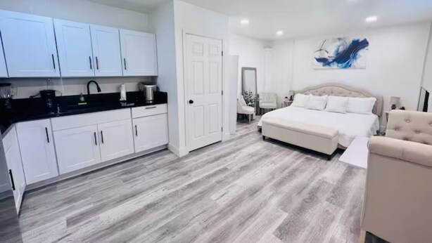 A modern bedroom with a large bed, a separate sitting area, and a kitchenette. - GORGEOUS Studio Guest House: Q Bed, Full SZ Fridge & Full SZ Washer & Dryer, BBQ (Phoenix)