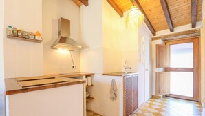 A kitchen with a wooden ceiling, a built-in stove, and a window with a view.