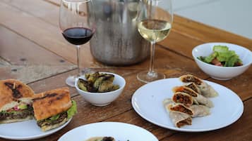 Una mesa de madera con diversos platos, una botella de vino y copas.