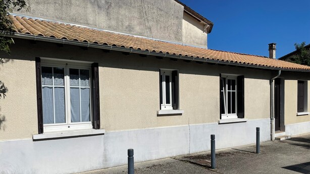 A building with a tiled roof, multiple windows, and a gravel ground. - Vacation rentals - Gîte Coulon (Coulon)