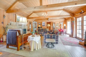 A spacious wooden interior with a fireplace, seating area, and dining space.