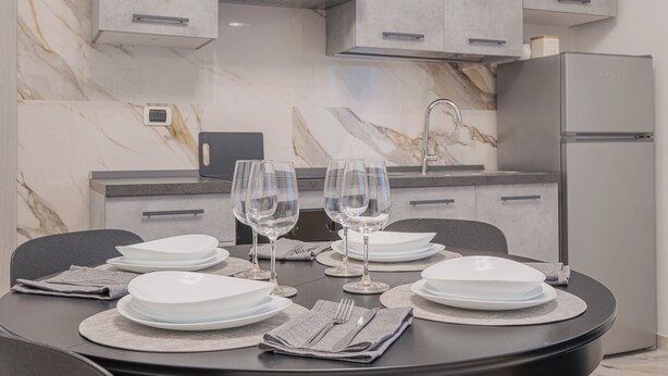 A modern kitchen with marble countertops, a built-in oven, and a refrigerator. - Rome Apartment Tuscolana Area (Metro A) ~Petit House~ (Roma)