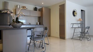 Una cocina moderna con una isla central, electrodomésticos de acero inoxidable y una planta de orquídea ornamental.