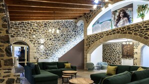A spacious interior with stone walls, green sofas, and a wooden staircase. - Villa Pasiphae - With Private Pool (Garazo)