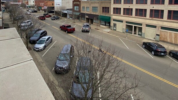 A street view with parked cars, buildings, and a clear sky. - Newly renovated 2 bdrm apartment in downtown (24) (Coshocton)