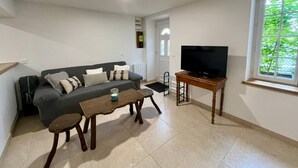 A living room with a sofa, coffee table, and TV stand.
