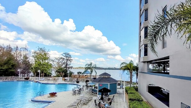A pool area with a hot tub, lounge chairs, and a view of the water.