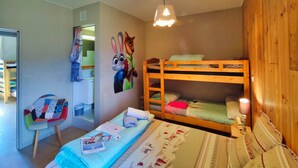 A room with bunk beds, a chair, a desk, and a wall with a rabbit and fox mural.