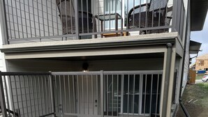 A patio area with a gravel surface and a metal gate.