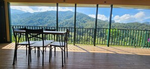 A balcony with a wooden floor and metal railing, overlooking a mountainous landscape. - Casita La Mariposa, Casita La Mariposa | Entire villa in Rivas, Costa Rica (Rivas)