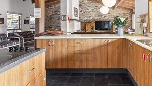A kitchen with wooden cabinets, a built-in stove, and a sink.