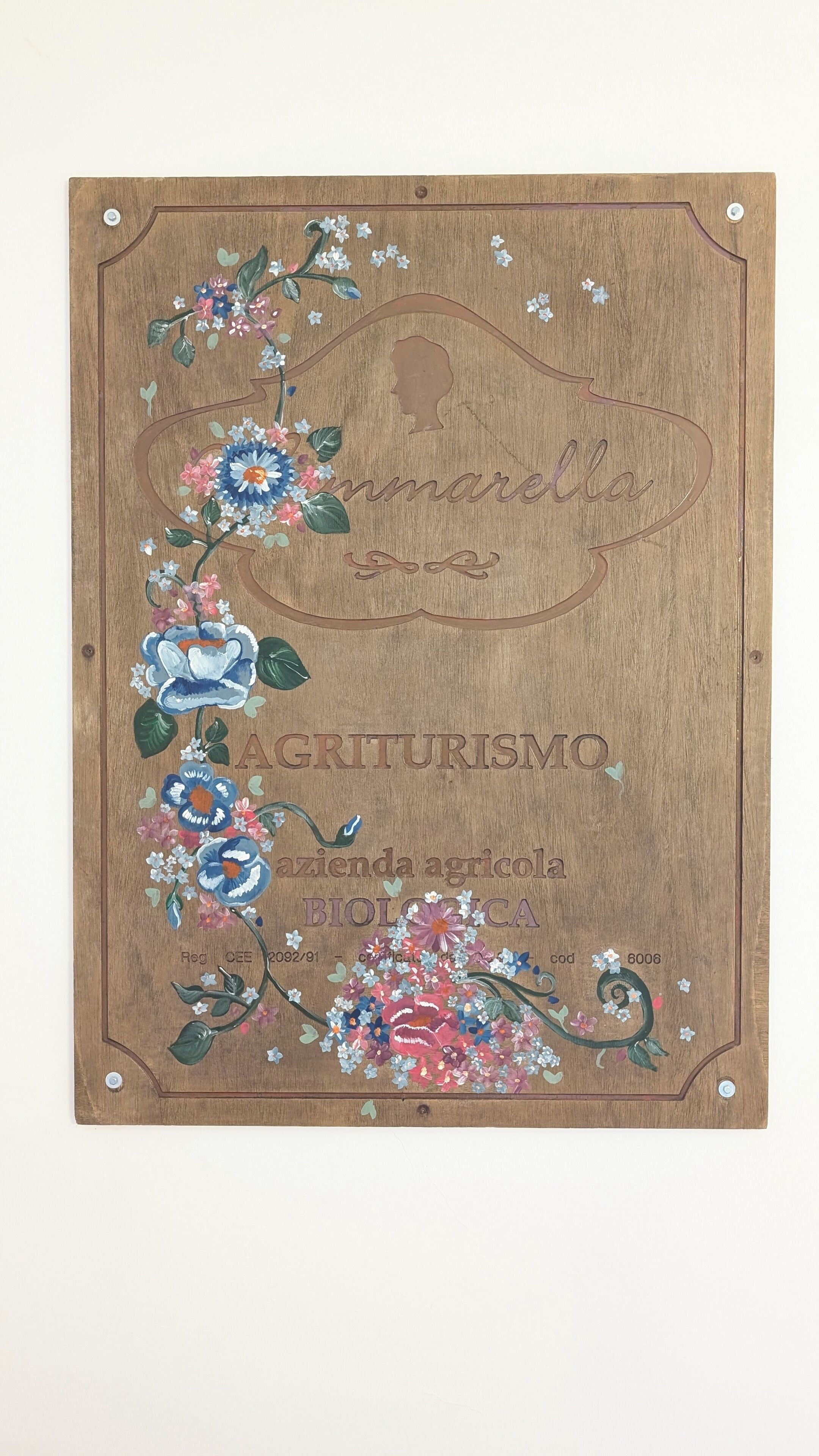 A wooden plaque with floral designs and text.