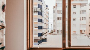 A view through a window of a multi-story residential building with balconies and a flat roof. - Beach House By Gt House (Silves)