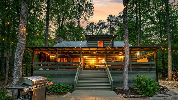 A cabin with a deck, a grill, and a view of the forest. - *Riverhouse on the Cartecay*WaterFront~Tube~Family (Ellijay)