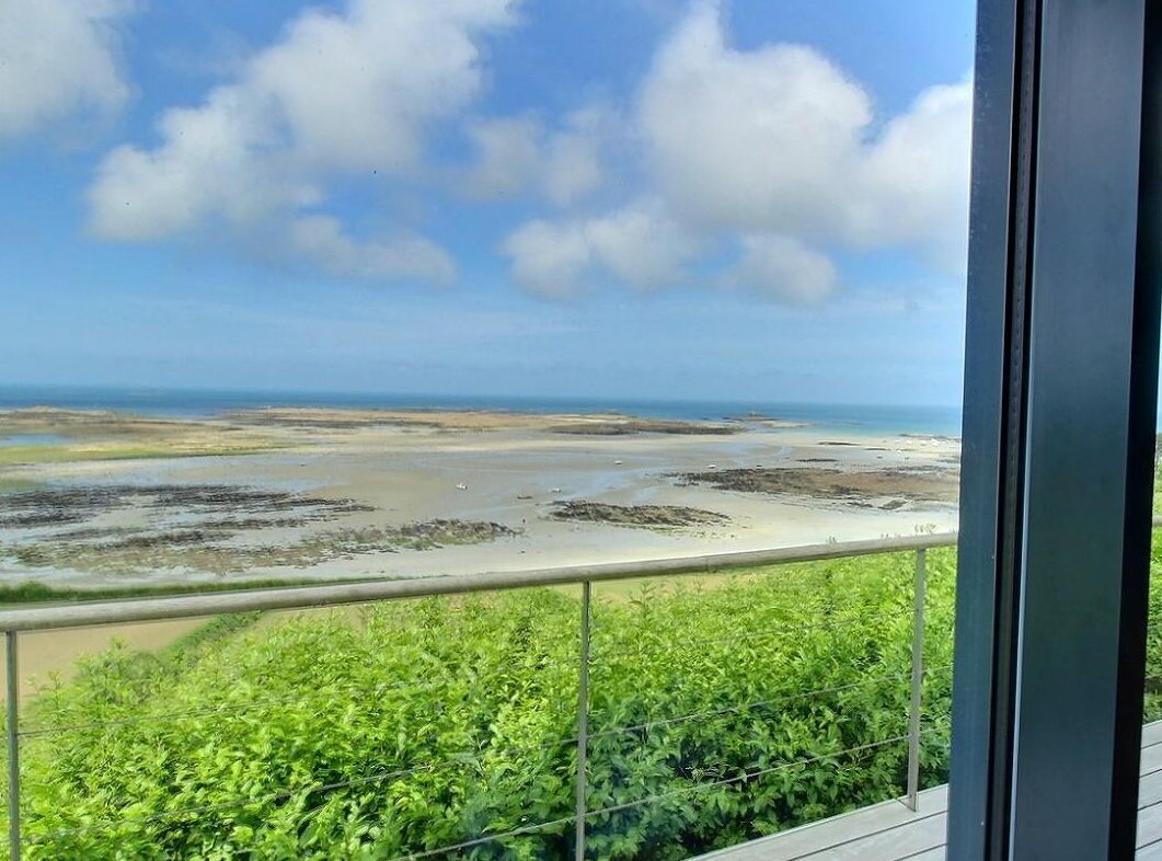 A balcony with a view of a beach and ocean.