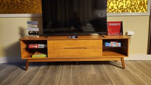 Eine Holz-Unterhaltungsecke mit Fernseher, Fernbedienung und einem Schild mit der Aufschrift Dr.unko.