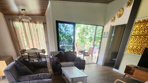 Ein modernes Wohnzimmer mit einem Ecksofa, einem Couchtisch und einem Streifenstuhl.