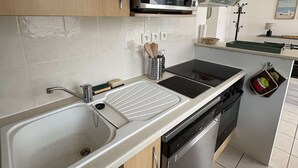 A modern kitchen with a stainless steel sink, a microwave, and a dishwasher.