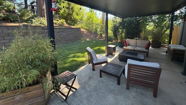 An outdoor patio with a covered seating area, including a sofa and chairs, a coffee table, and a small table. - Your Home in Sandy – Comfortable, Convenient & Affordable (Sandy)
