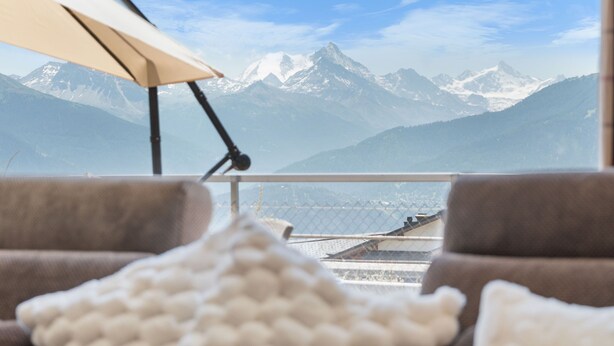Un balcón con vistas a montañas nevadas.