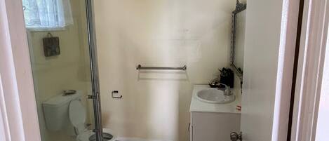 Een badkamer met toilet, wastafel en douche.