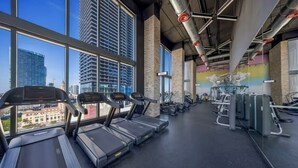A gym with treadmills, weight machines, and a city view. - Vaca Rentalz Downtown Miami 1BR + Pool, Gym (Miami)