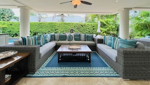 A covered outdoor seating area with a ceiling fan, a central table, and a patterned rug. - Tropical Holiday Rental Villa - Villatre (Mullins)